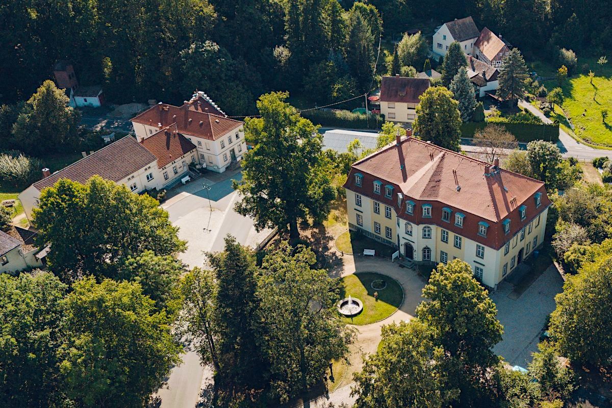 Luftaufnahme des Dorfzentrums Mittelhof in Sohland am Rotstein mit Schloss, Vorplatz, Gr�nanlagen und angrenzender Bebauung.